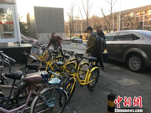 在北京街頭的一處共用單車停車點，有小孩在嘗試解鎖。湯琪 攝