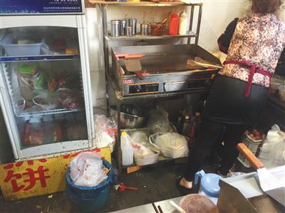 同時入駐了三家外賣平臺的“臺灣手抓餅”店內(nèi)，老闆娘正在加工食物，店內(nèi)衛(wèi)生條件差。後該店被查出無證經(jīng)營。新京報記者 張越攝