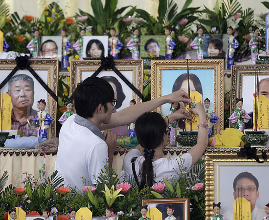 7月24日，臺(tái)灣澎湖，兩名親屬在遇難者的遺像前插香祭奠。