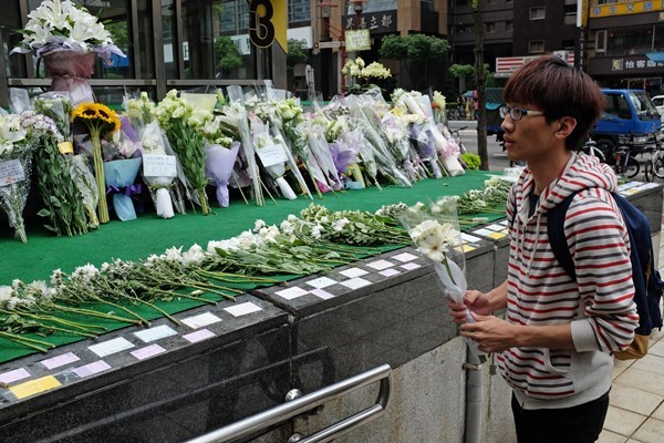 民眾到站外獻(xiàn)白花吊慰亡靈