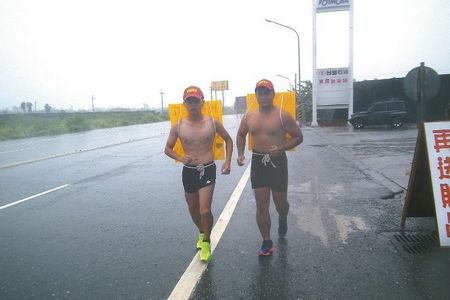 臺灣兩大學(xué)生不畏風(fēng)雨 打赤膊背廣告牌慢跑環(huán)島(圖)