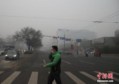 資料圖：一名戴著口罩的行人走在北京街頭。中新社記者 張浩 攝