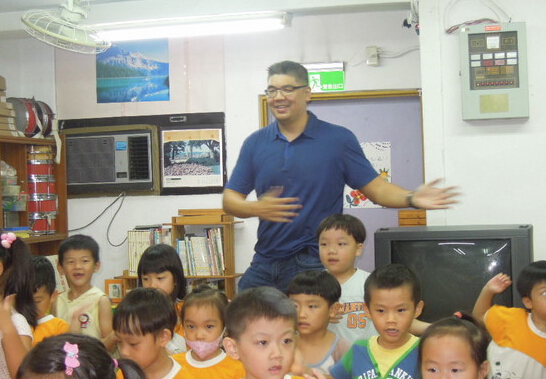 連勝文到幼兒園參訪，席地而坐和小朋友講故事。（臺媒圖）