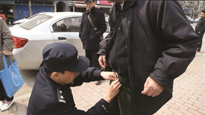 民警幫老人穿好褲子。